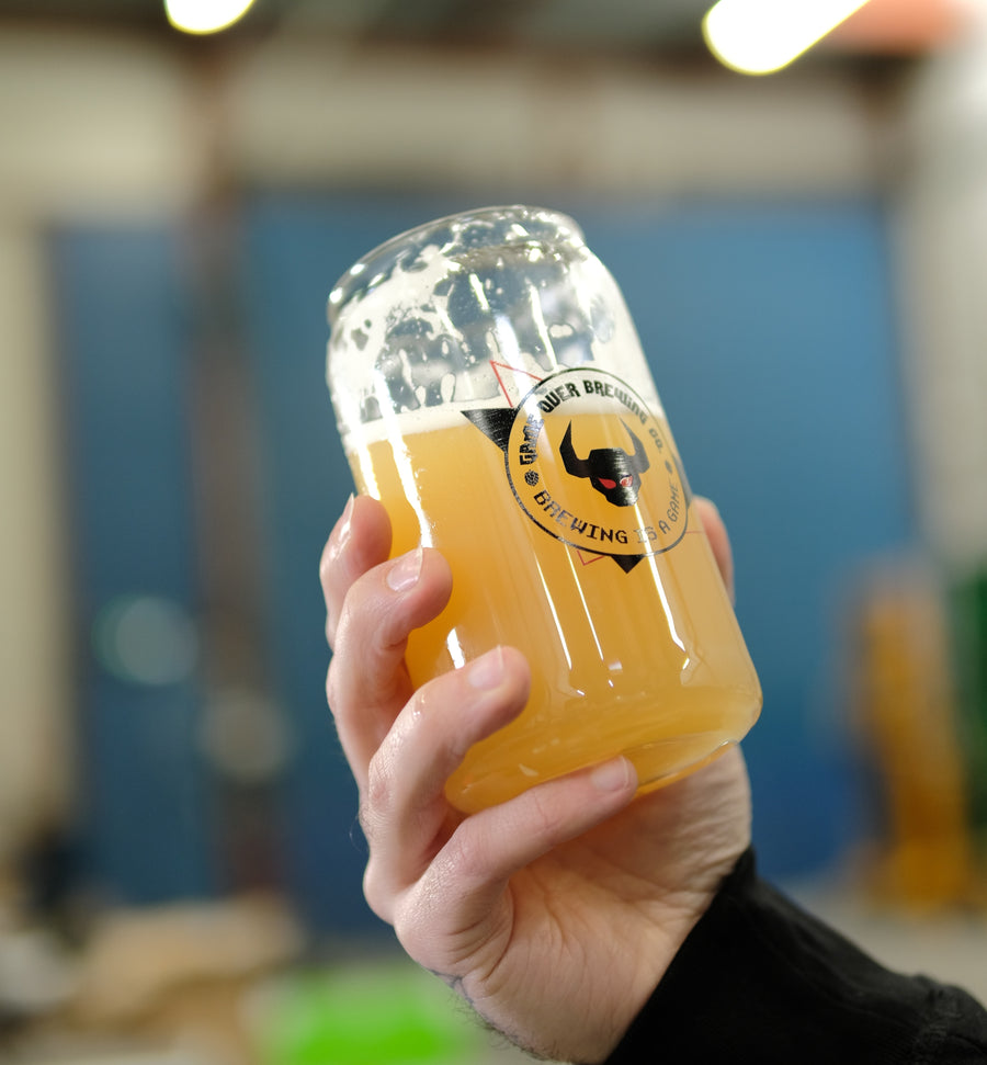 Un verre de bière trouble Game Over Brewing tenu à la main, à la brasserie de Toulouse