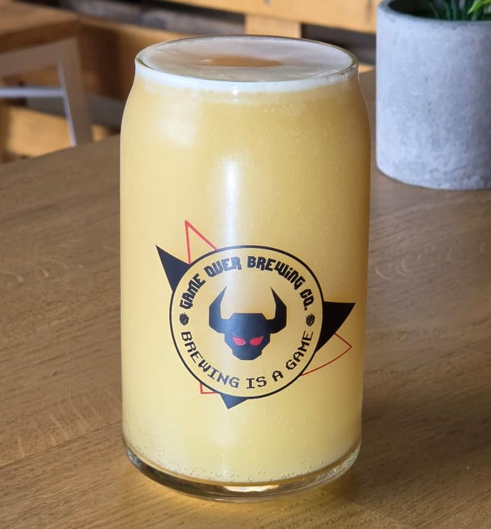 Une bière Game Over Brewing servie dans un verre au logo de la brasserie